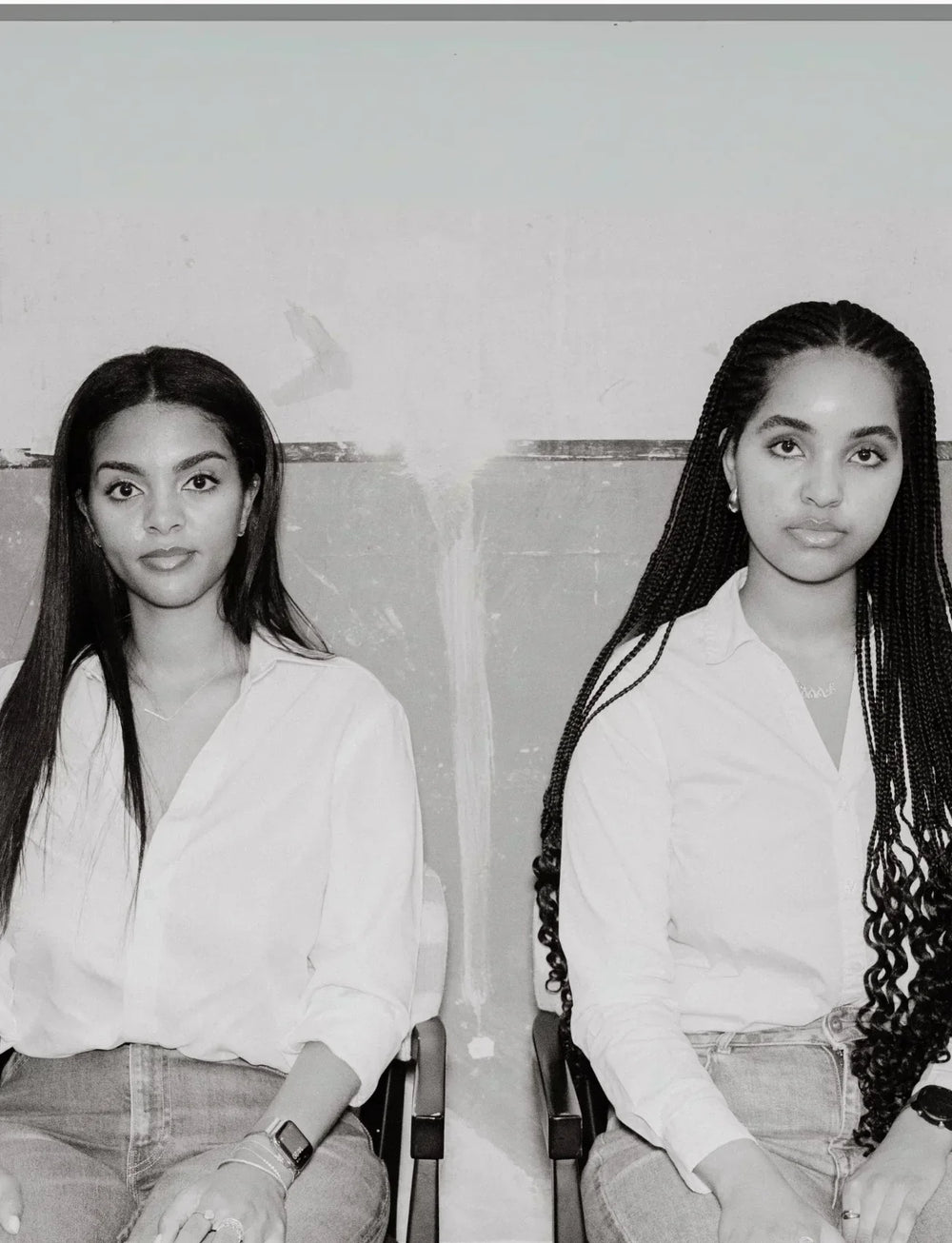 black and white photo of the Artamine founders, the Gizaw sisters, sitting next to each other