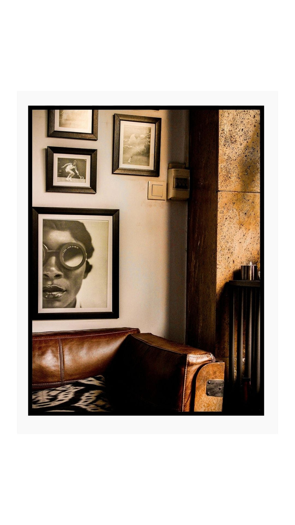 Start art collection wall with framed prints above leather sofa